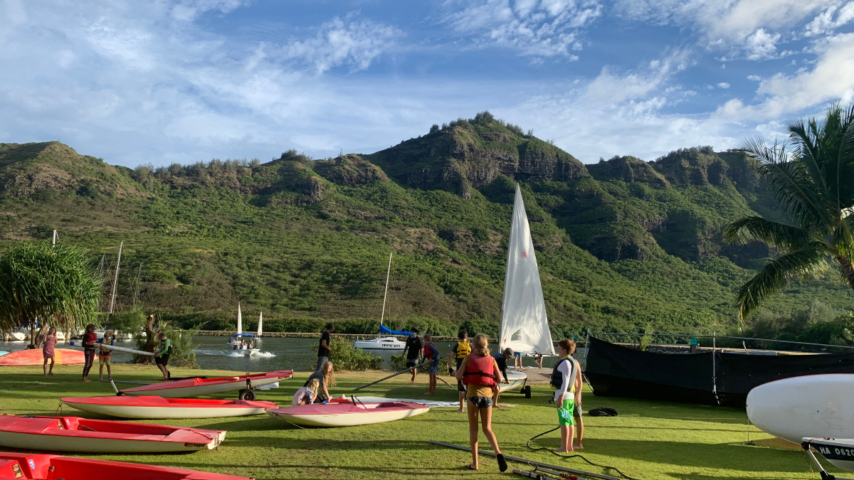 Alaka'i O Kaua'i learner outside with friends with boats near water