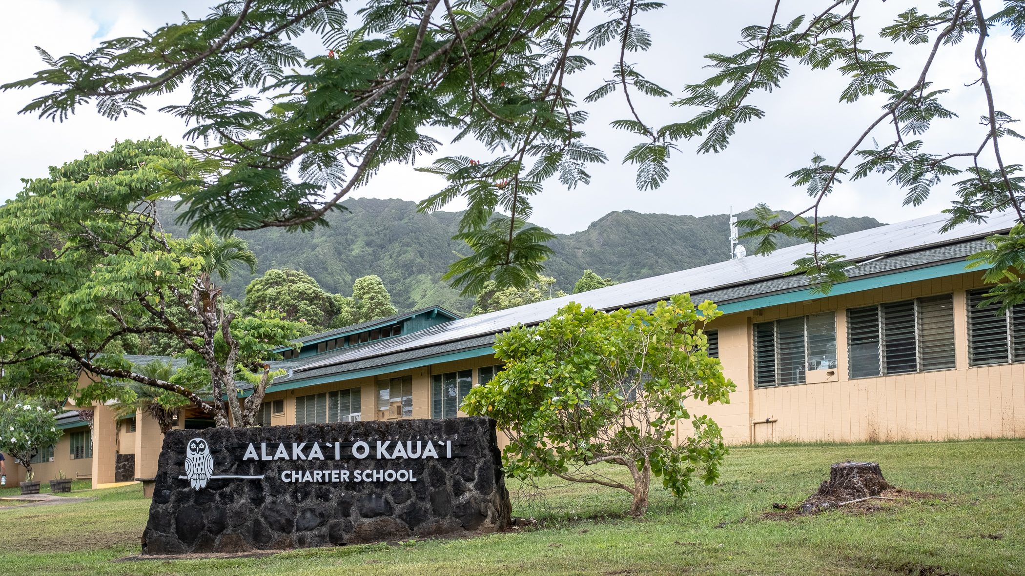 image of the "AOK" sign with the school building in the background