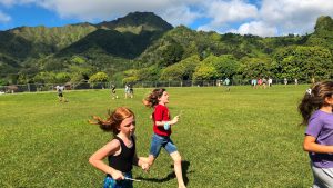 student running in a field, mountains in the background