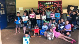 AOK students holding up their colorful Valentine's Day artwork.