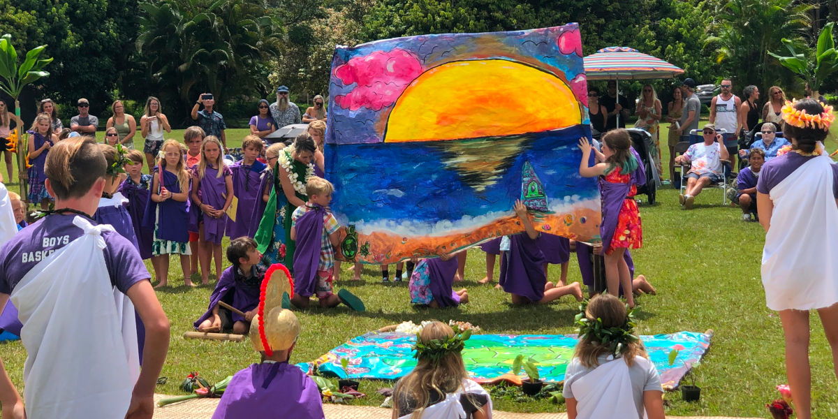 AOK learners holding a large painting of the sunset
