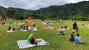 AOK learners reading in a green field