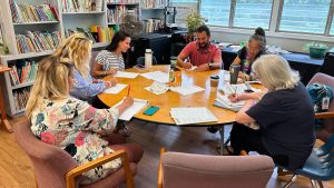 AOK teachers sitting around a table together