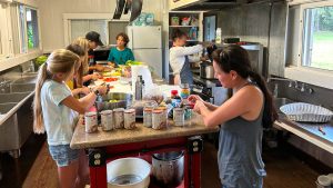 AOK learners standing around a table preparing food to cook 