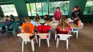 a group of 7 AOK learners sitting around a table working on school work