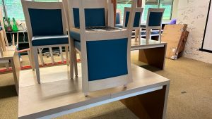 white chairs stacked on a desk in an AOK classroom